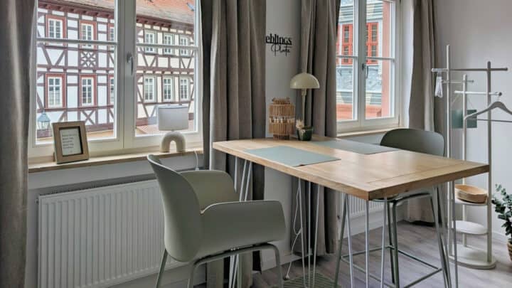 MainZauber Apartments früher MainTerrasse Miltenberg am Main - Modernes, minimalistisches Homeoffice mit Holztisch und Blick auf Fachwerkhäuser - luxuriöse Ferienwohnung Altstadt Miltenberg.