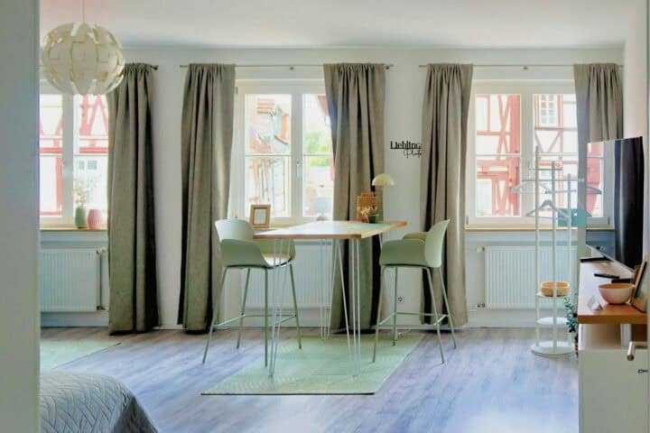 MainZauber Apartments früher MainTerrasse Miltenberg am Main - Luxuriöses Apartment für den Urlaub: Helles Wohnambiente, großes Fenster, Holztisch, minimalistisch, zentrale Unterkunft Miltenberg.