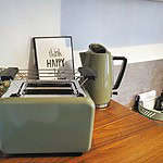 Erleben Sie den perfekten Urlaub in unserem luxuriösen Apartment, in dem jedes Detail auf Ihren Komfort ausgelegt ist. Die elegante Küche verfügt über eine elegante Holztheke mit einem stilvollen grünen Toaster und einem passenden Wasserkocher, sodass Sie Ihren Tag wunderbar beginnen können. Eine bezaubernde Topfpflanze und ein inspirierender gerahmter Druck mit der Aufschrift „think HAPPY be HAPPY“ geben den Ton für Ihren Aufenthalt an und schaffen ein gemütliches und modernes Ambiente. Wählen Sie diese erstklassige Unterkunft für Ihren nächsten Urlaub und genießen Sie einen unvergesslichen Rückzugsort in unserem Luxusapartment. - MainZauber Apartments Miltenberg am Main