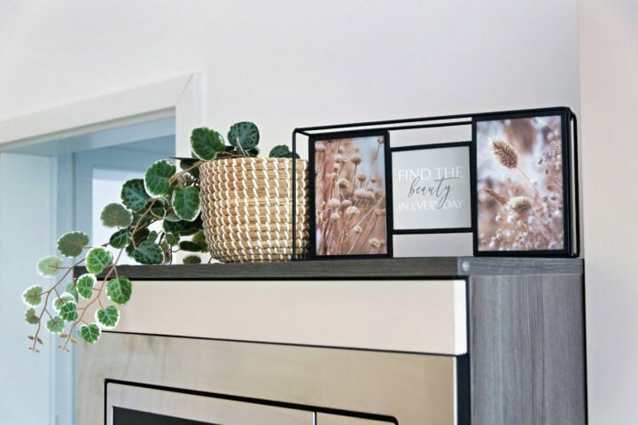 MainZauber Apartments früher MainTerrasse Miltenberg am Main - In unserer luxuriösen Ferienwohnung in der Altstadt steht ein Korb mit Pflanze auf dem Schrank, daneben stilvolle Bilderrahmen.