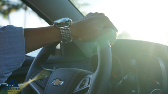 A man driving with one hand on the wheel