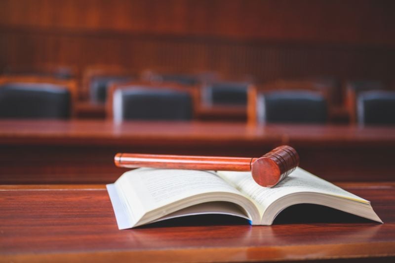 open book in court room with gavel laid across it