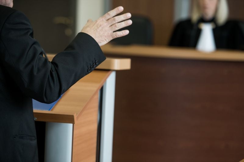 lawyer speaking at podium in front of judge