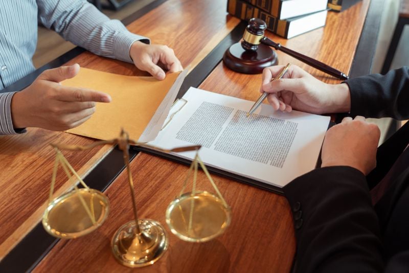 Lawyer and client sitting at table reviewing legal documents
