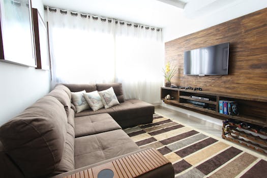 Home Stylish modern living room featuring a brown sofa, wall-mounted TV, and interior decor.