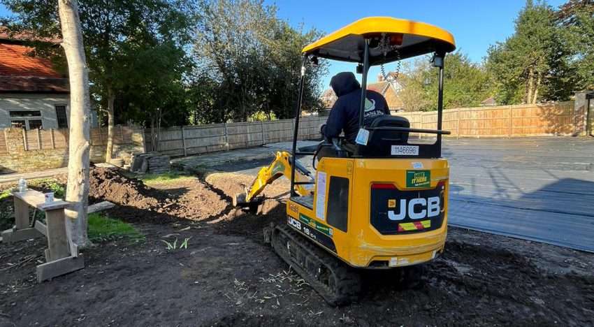 A flooded garden in Kingston showing standing surface water, with text promoting soakaway installation as a long-term drainage solution.