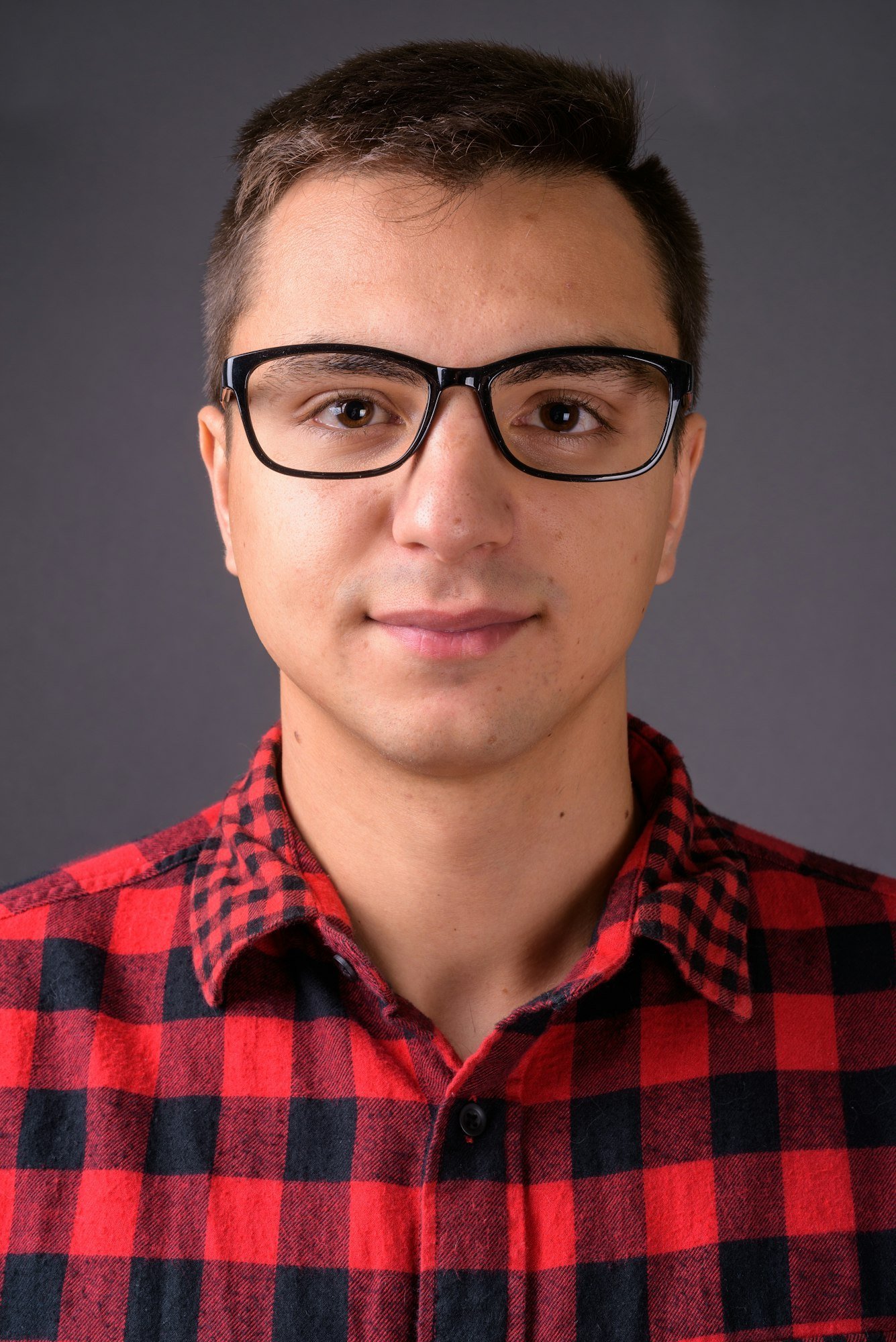 Studio shot of young handsome man against gray background