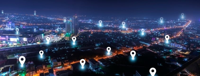 A nighttime cityscape with glowing map location markers, reminiscent of Google Maps, highlights various points of interest for home buying. The city’s tall buildings and illuminated roads shine brightly. Showcase IDX branding appears in the bottom right corner.