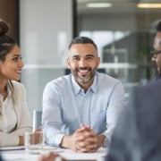 Business leader listening to diverse team in meeting.