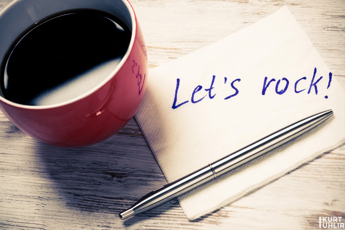 Cup of coffee and napkin with writings on table