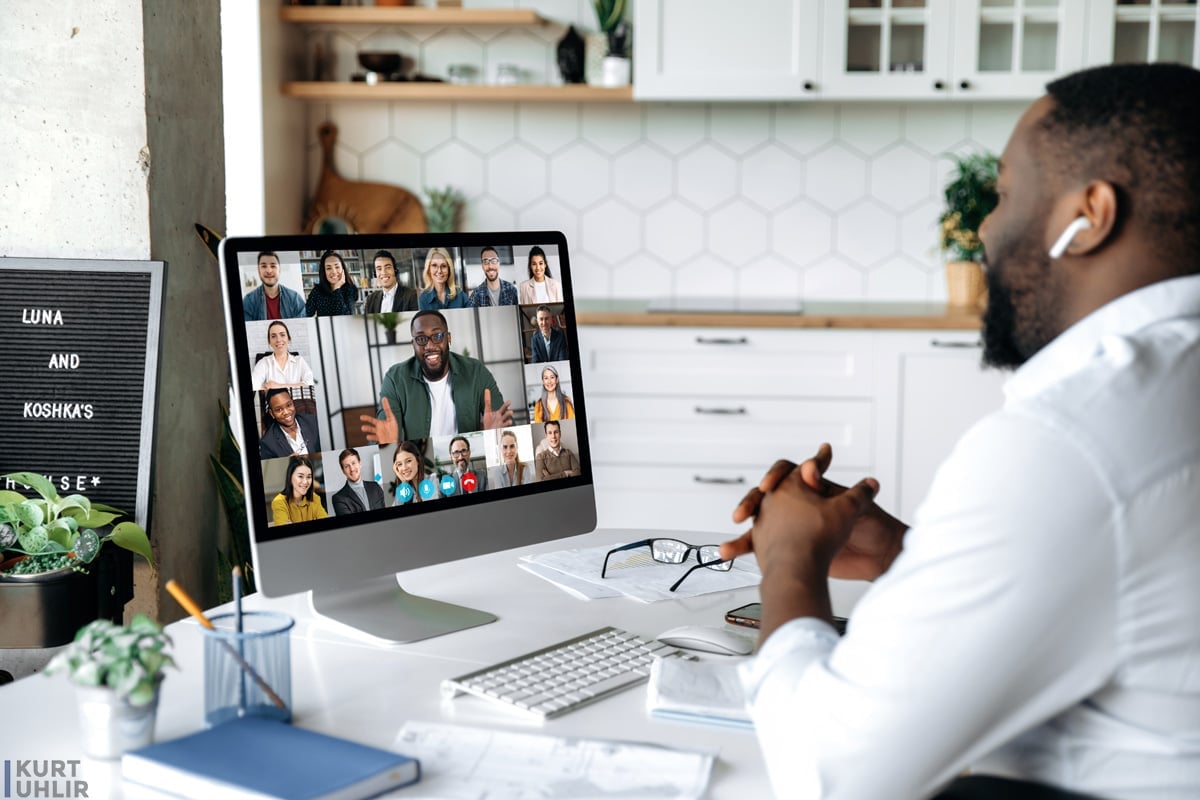 Video conference. online meeting. Intelligent business man sits at work desk at home, looks at the computer screen, communicates by video call with his partners, discuss a strategy