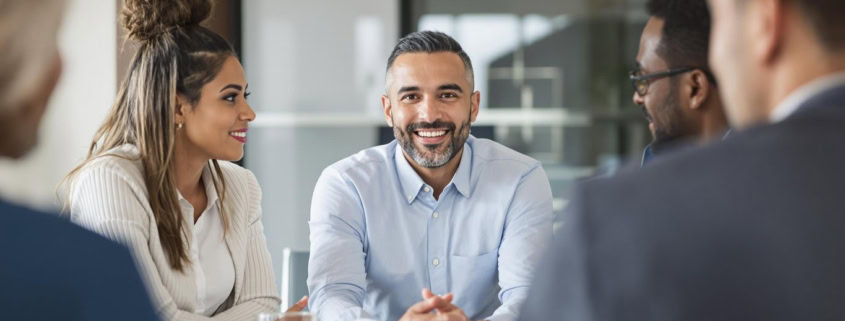 Business leader listening to diverse team in meeting.