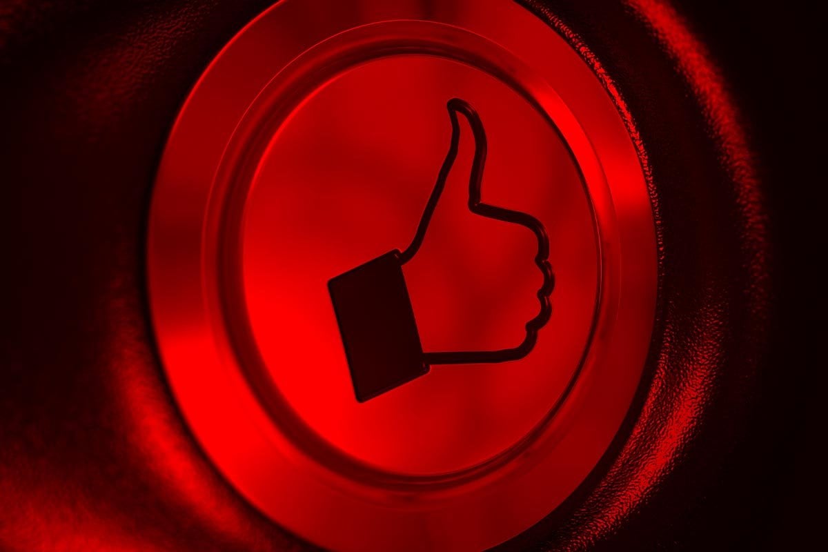 Un botón rojo con un signo de pulgar hacia arriba para promocionar en Facebook.