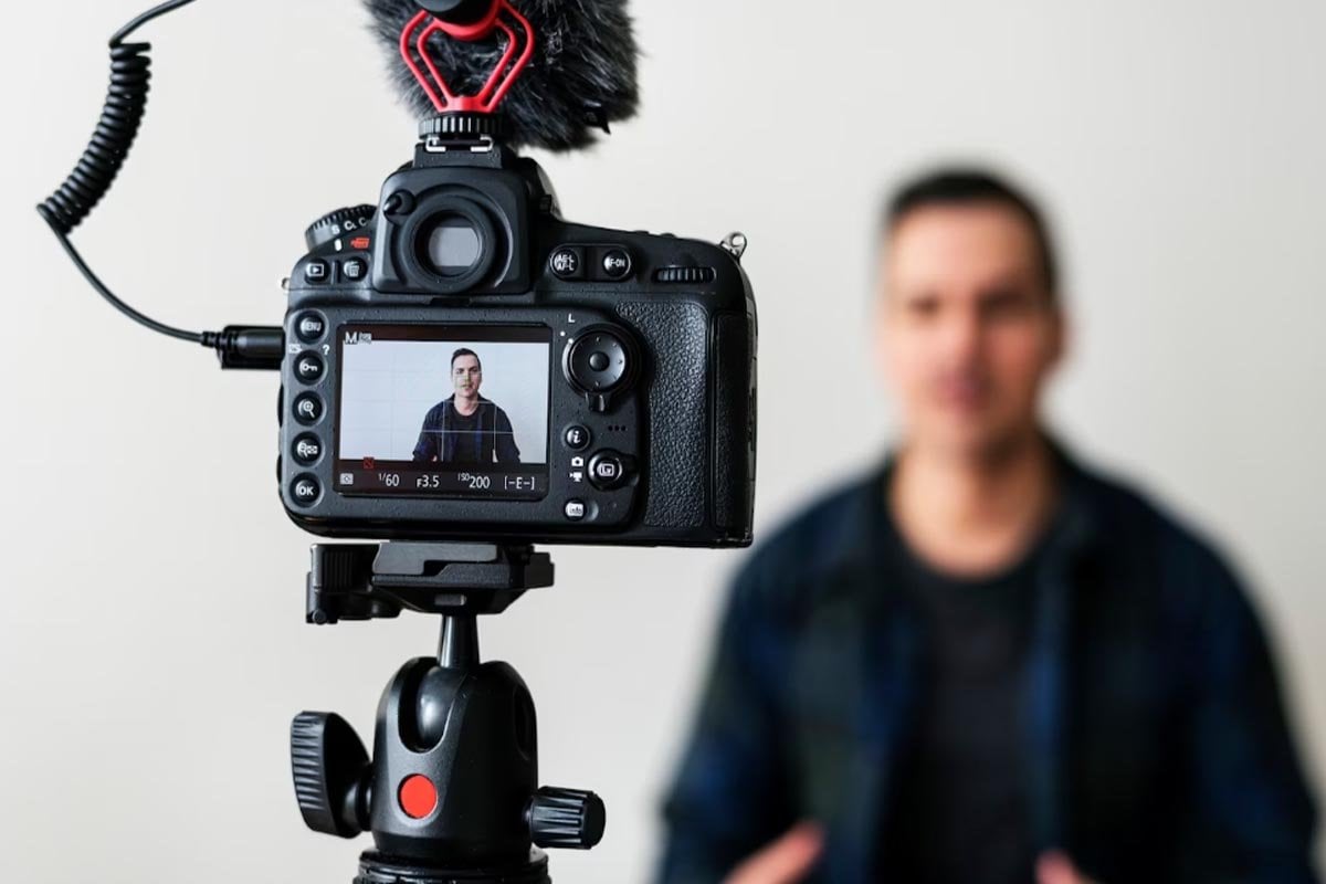 Un hombre está usando video marketing sosteniendo una cámara y grabando un video.