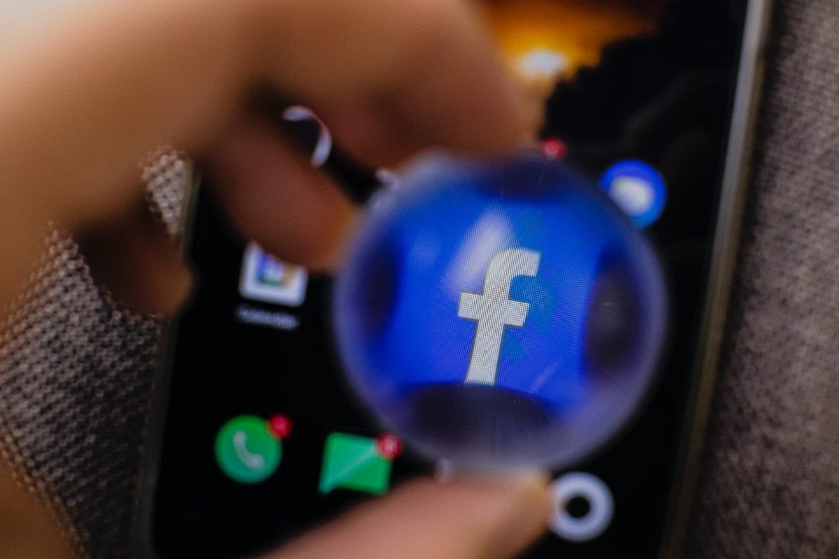 Una persona está utilizando la segmentación para mantener un logotipo de Facebook en un teléfono celular.
