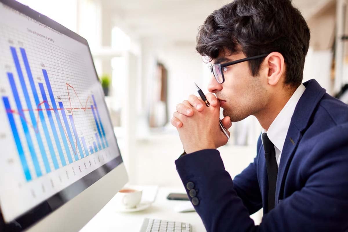 Un hombre de negocios que analiza los datos de la competencia en la pantalla de su computadora.