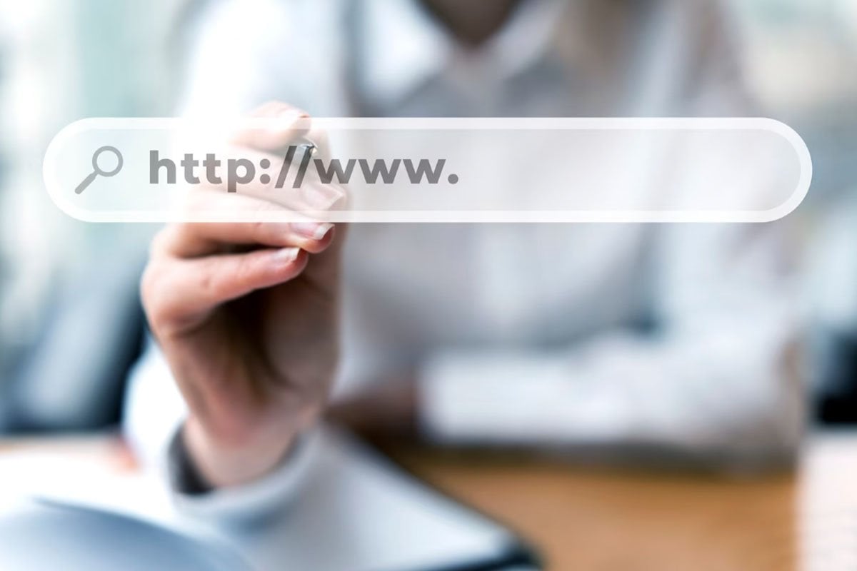 Una mujer sostiene un marcador y señala una página de destino en un sitio web.