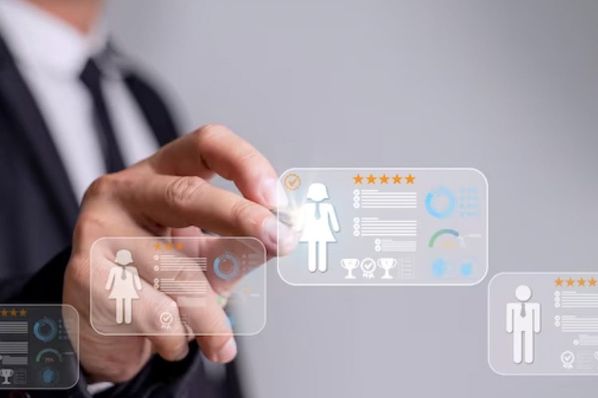 Un hombre de negocios señala a una persona en una pantalla mientras habla sobre anuncios de Facebook personalizados para un público objetivo.