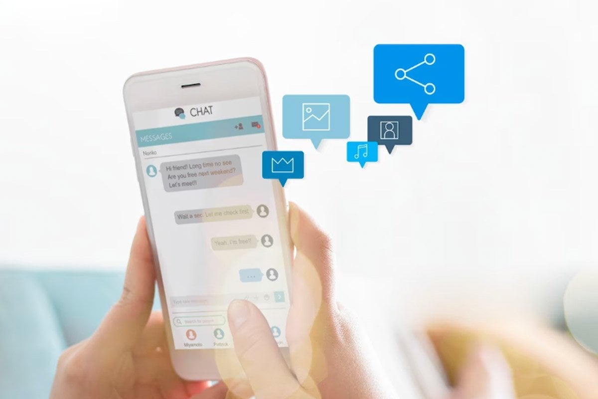 Una mujer sostiene un teléfono integrado con chatbot con íconos de mensajes de texto.