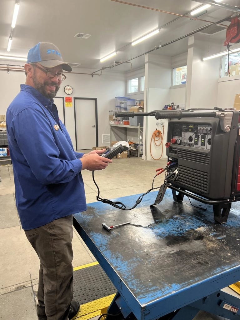 man working at the parts and service department using machine and smiling
