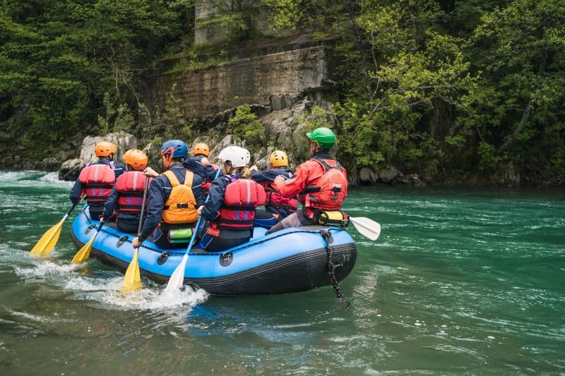 group rafting trip down the river with helmets