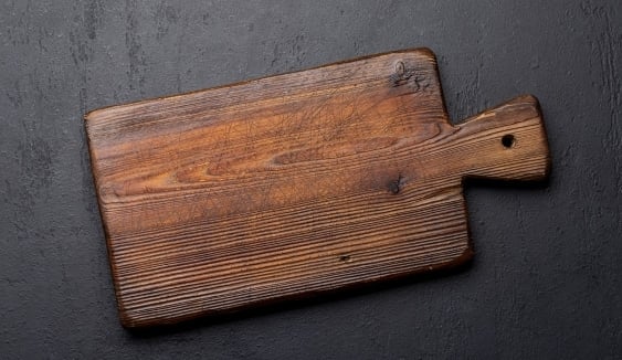 wooden cutting board on black surface
