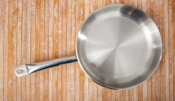 stainless steel pan on wooden surface 
