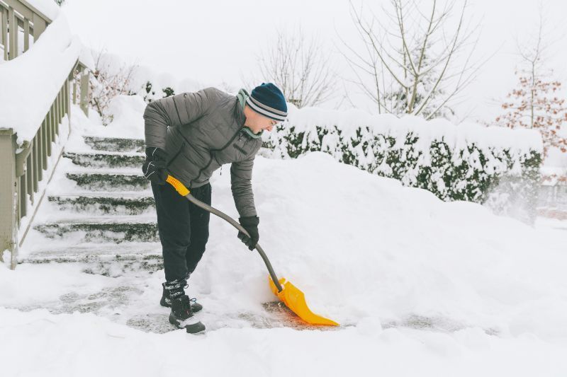 history of snow blowers, man shoveling snow by hand
