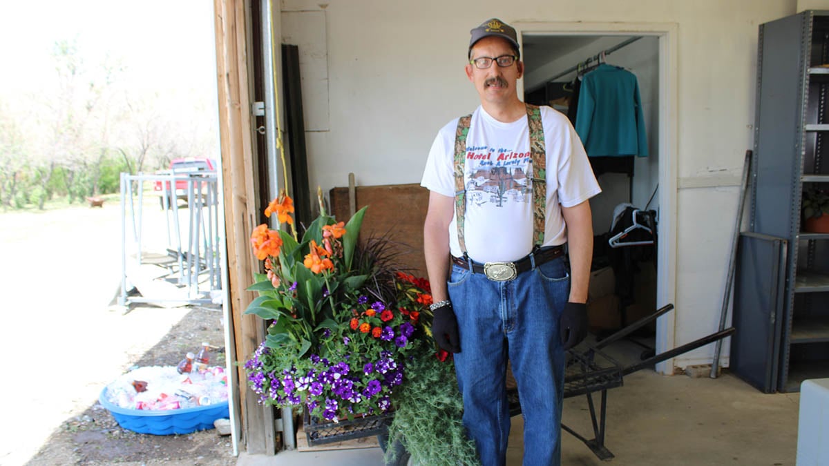 a man standing next to flower starts