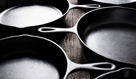 cast iron pans on wooden surface