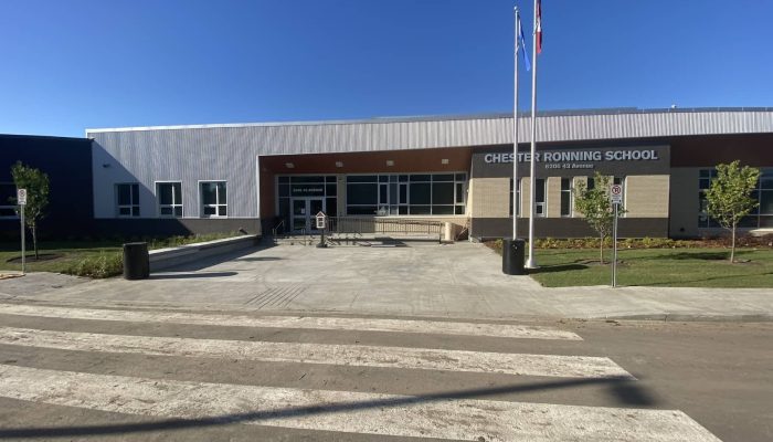 Cover Photo_Chester Ronning Exterior a building that has a sign on a dirt road