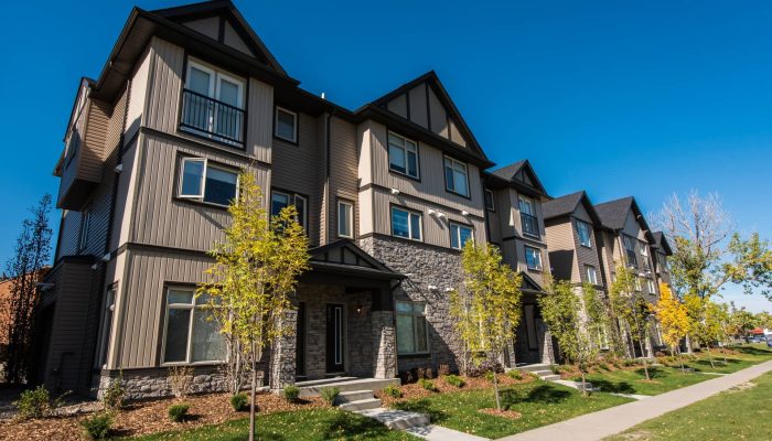 Applewood Townhomes a large brick building with grass in front of a house