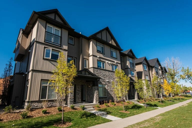 a large brick building with grass in front of a house