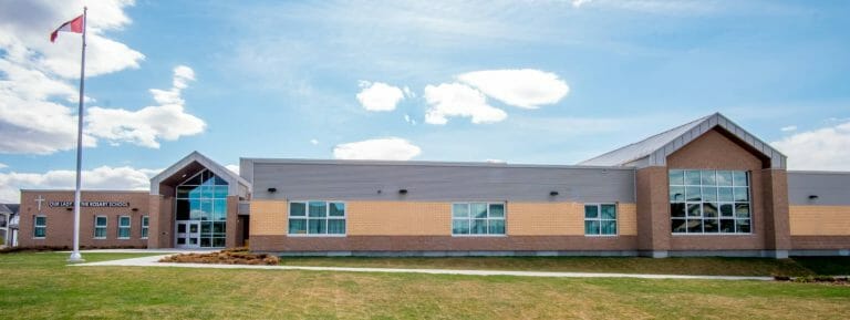 a large brick building with grass in front of a house