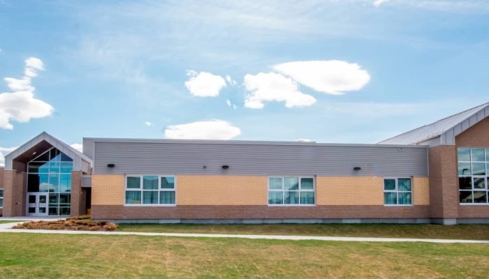 Our lady of the rosary school a large brick building with grass in front of a house