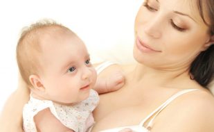 A woman gazes lovingly at the baby in her arms, who looks upwards with a curious expression. They are both bathed in soft, natural light. A woman gazes lovingly at the baby in her arms, who looks upwards with a curious expression. They are both bathed in soft, natural light.