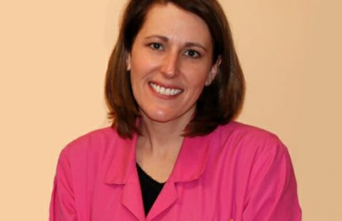 Woman in a pink uniform smiling at the camera. Woman in a pink uniform smiling at the camera.
