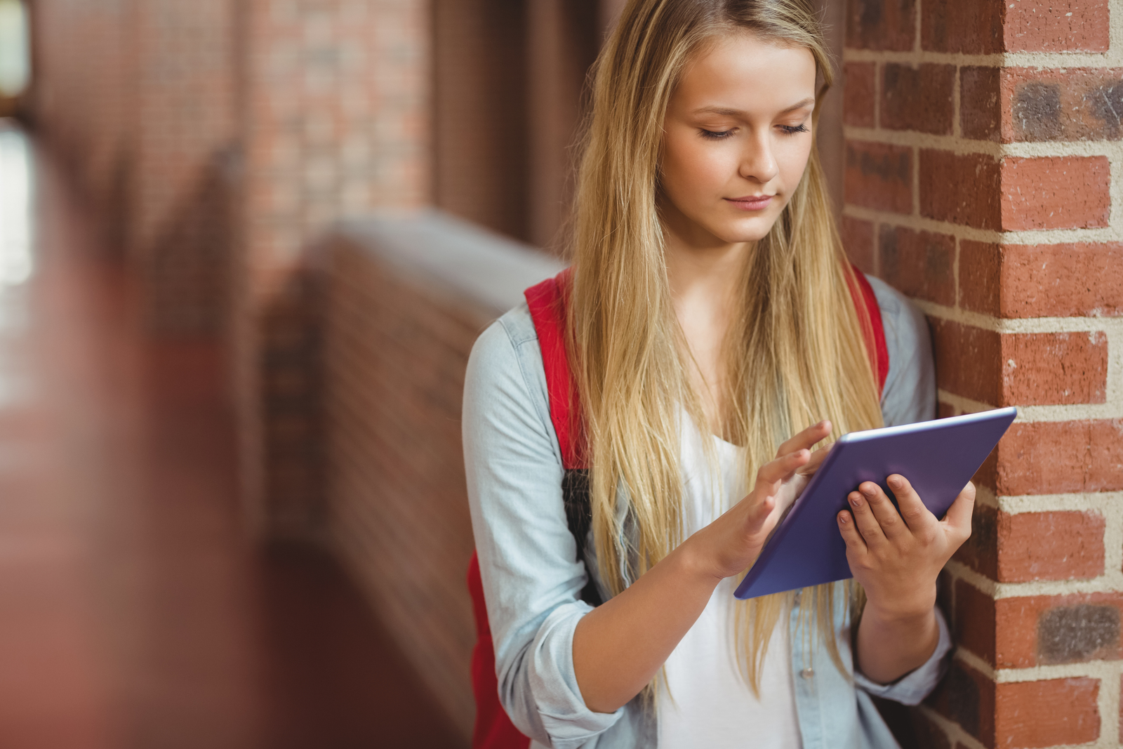 Student using tablet in the hallway - students need a motivation letter for erasmus to be accepted into the program