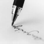 pen signing a piece of paper