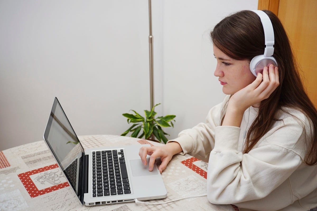 teenager study at home online with laptop and mobile and headphones