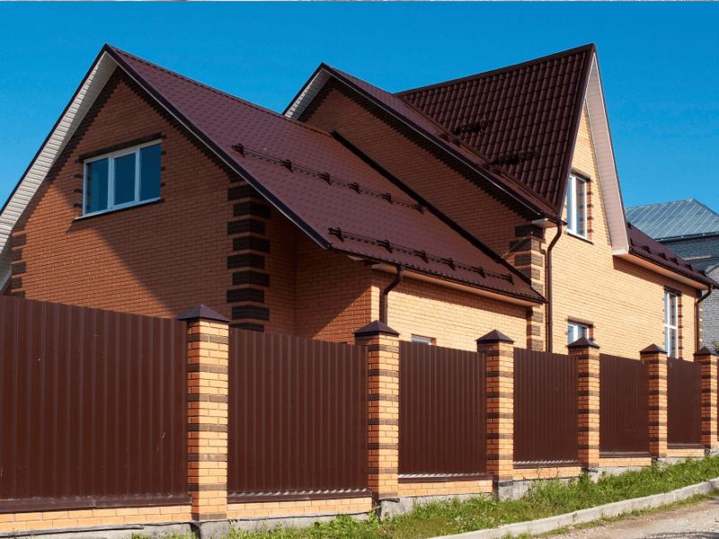 Casă cu țiglă metalică și gard de metal