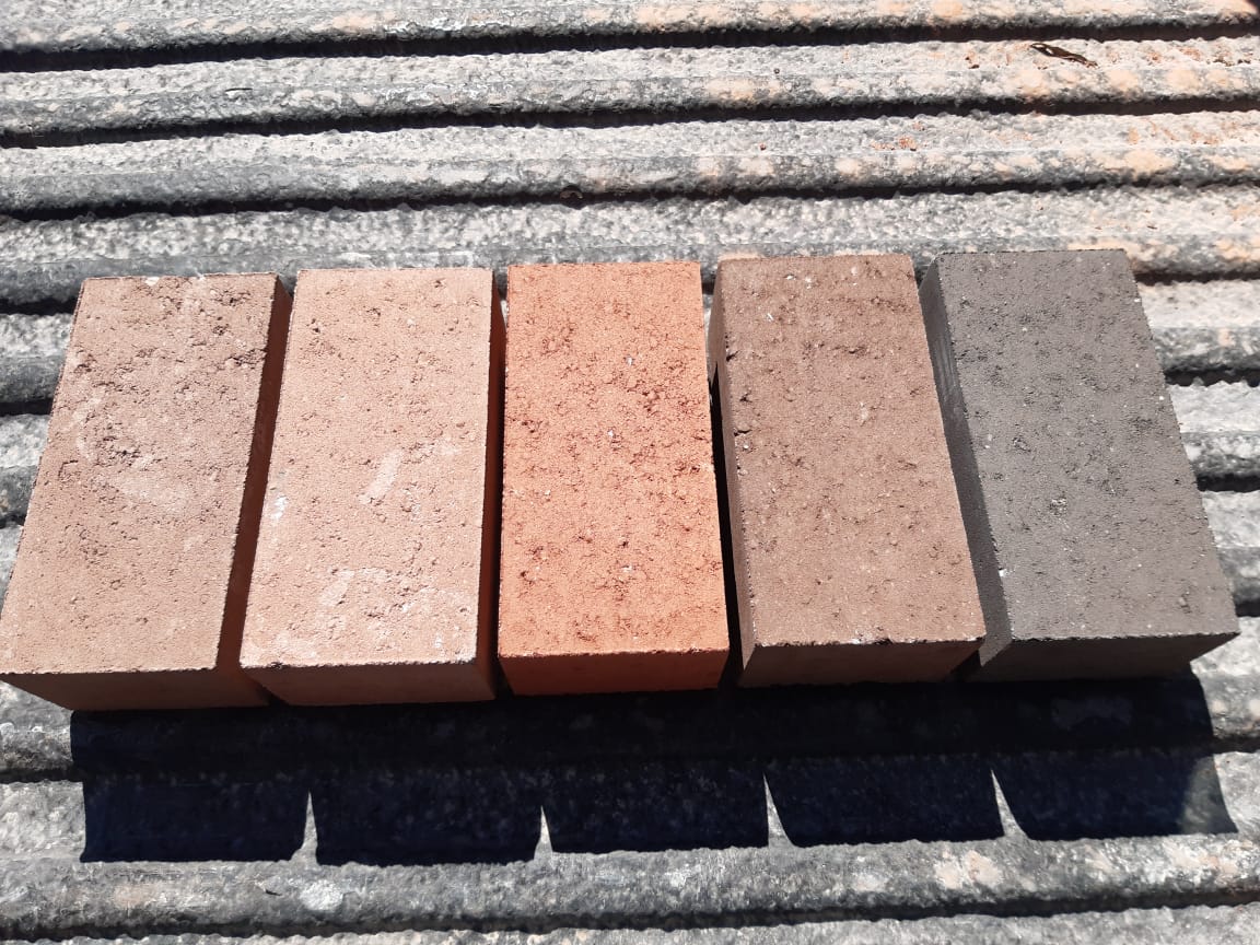 Five different coloured cement bricks laid out in a row