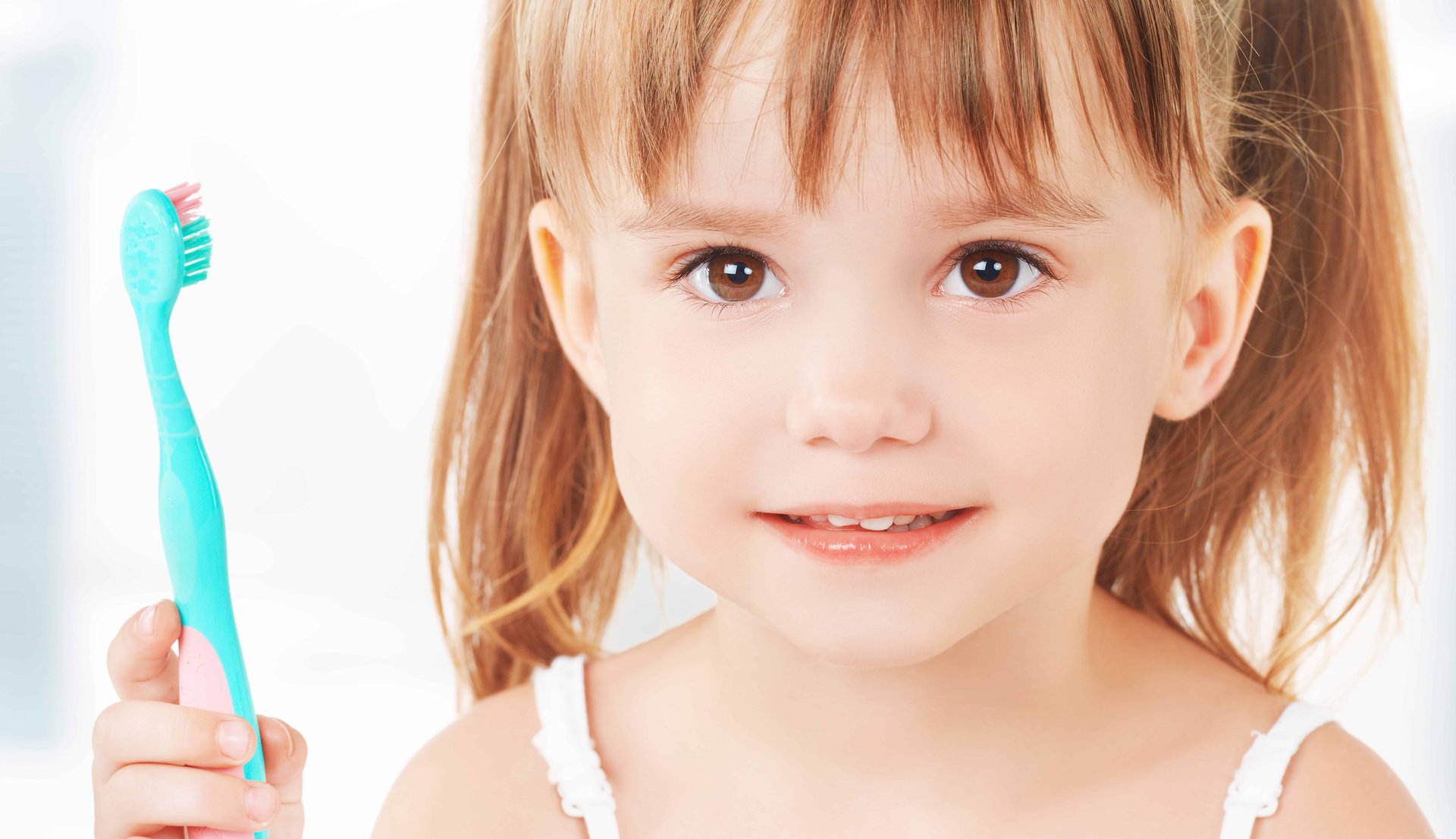 Starke Zähne mit Fluoriden happy little girl brushing her teeth