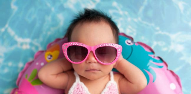 Sonnenschutz! Sonne sicher genießen Sonnencreme und Sonnenhut am Strand, Newborn Baby Girl Wearing Sunglasses and a Bikini Top