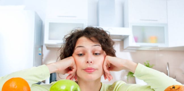 Typ-2-Diabetes ist ein wichtiger Risikofaktor für Schlaganfall Dieting concept. Young Woman choosing between Fruits and Sweets