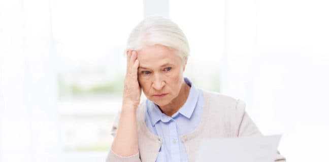 Betriebsrentner verlieren Anspruch an deutschen Arbeitgeber nach vereinfachter Sitzverlegung senior woman with papers and calculator at home