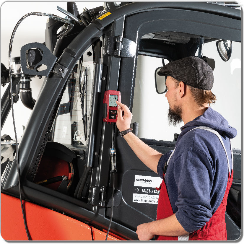 Man checking gas analyzer on heavy equipment.