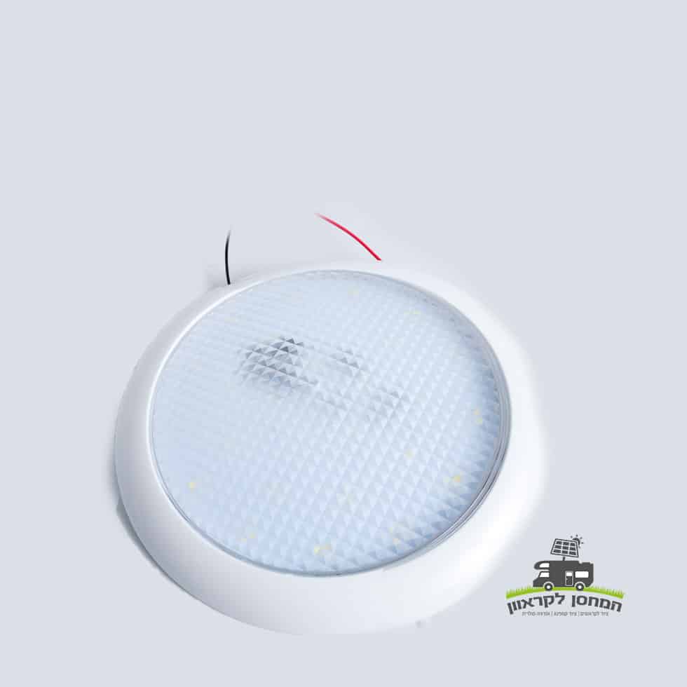 פנס תאורה פנימית 12V 24W &ndash; גוף תאורה עגול בצבע לבן עם מפזר אור מחוספס, חוטים אדום ושחור גלויים, מתאים לשימוש במערכות אנרגיה סולארית, פוטו-וולטאית טכנולוגית ותשתיות ייצור חשמל מתחדשות לקרנים וקמפינג; לוגו ירוק עם כיתוב בעברית בפינה הימנית התחתונה.