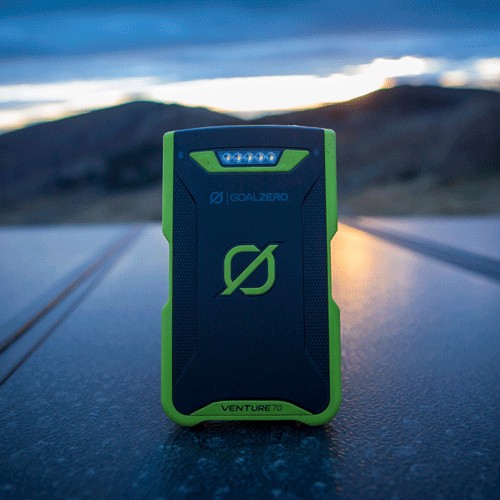 סוללת גיבוי IP67 71Wh VENTURE70 עם פנסים מובנים, מצולמת בחוץ בזמן דמדומים על רקע הרים—פתרון אידיאלי לאגירת אנרגיה סולארית ולמערכות פוטו-וולטאיות ניידות, תומך בייצור חשמל אנרגיה מתחדשת ובתחנות כח ביתיות.