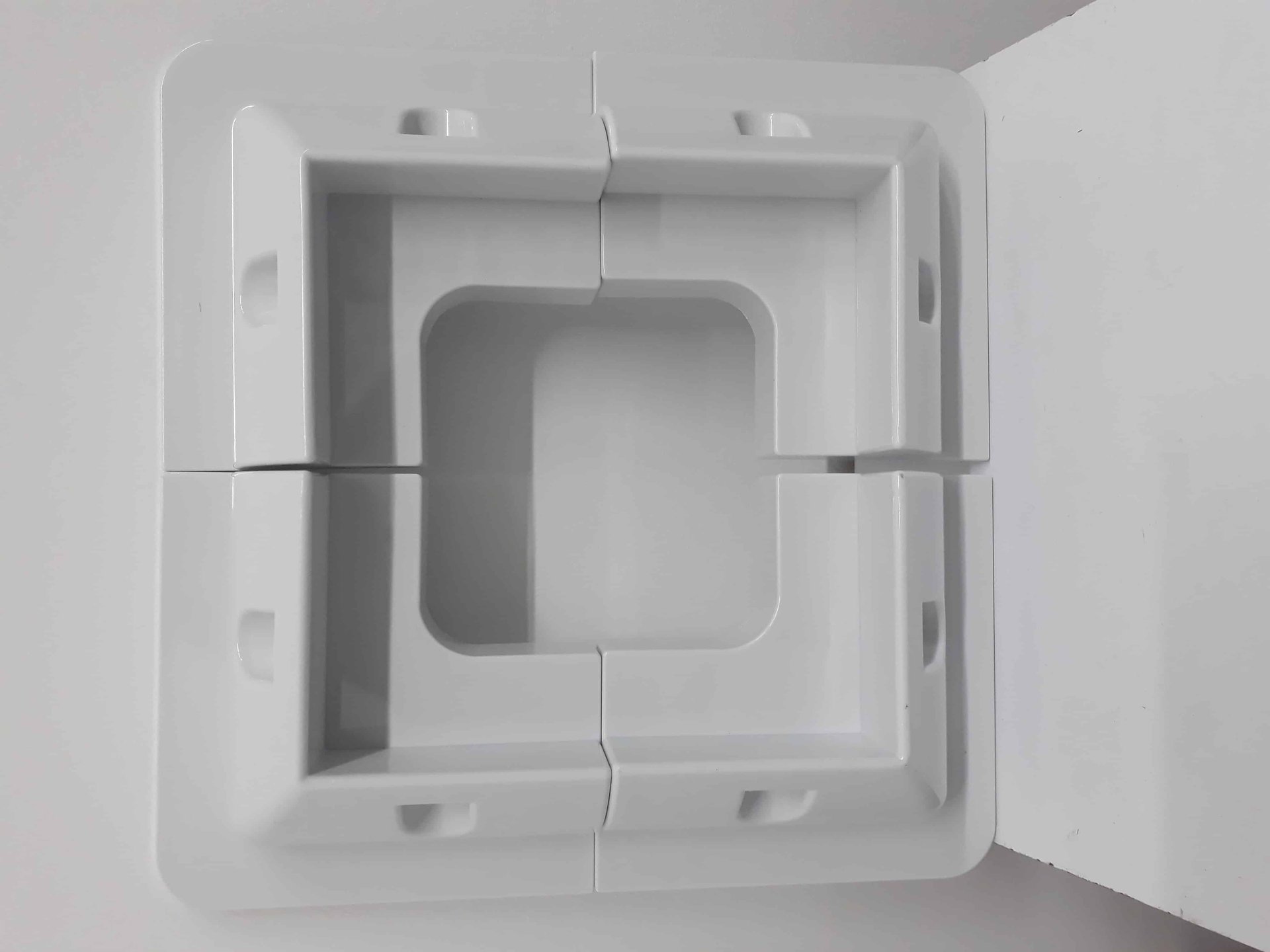 סט תושבות לפאנל סולארי: מסגרת מלבנית לבנה מפלסטיק, מורכבת מארבעה חלקים נפרדים להתחברות קלה לפאנלים פוטו-וולטאיים, אידיאלית להקמת מערכת ייצור חשמל ביתית באנרגיה סולארית ולחיזוק תשתיות אנרגיה מתחדשת.